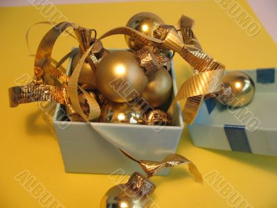 Open blue gift box with golden balls