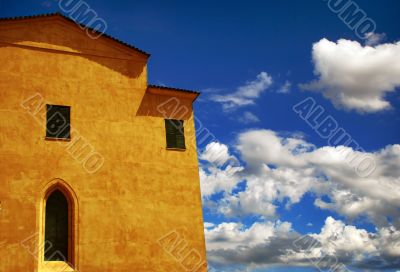 yellow building with cloudy sky in the background