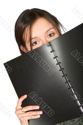 beautiful teen peeping over notebook