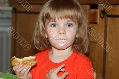 Little pretty blond girl eating pancake