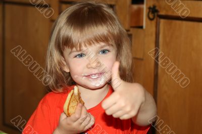Little pretty blond girl eating pancake