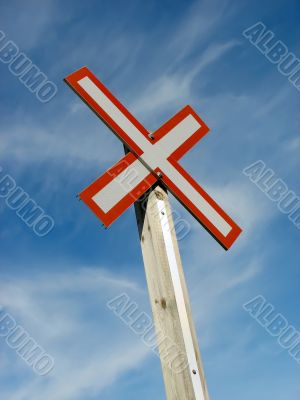 Railroad crossing sign on a blue sky background