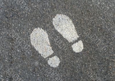 Painted footprints on asphalt