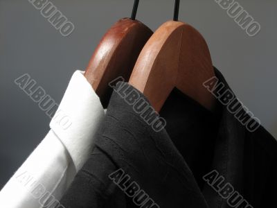 Black and white shirts on wooden hangers