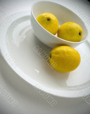3 lemons in a bowl, tilted view