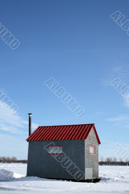 Ice fishing hut under the blue sky