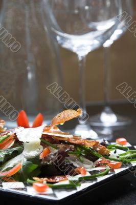 Salad with wine glasses in the background
