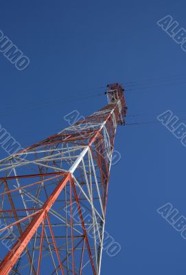 Red and white power tower in the blue sky