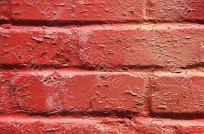 Red peeling paint on a brick wall