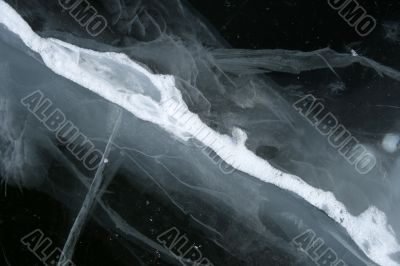 Cracked snowy ice, deep black water