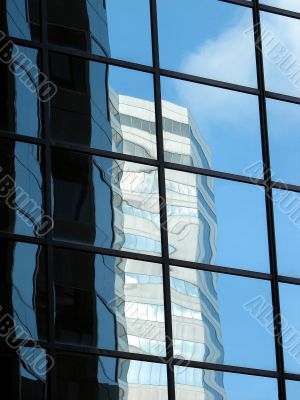 Corporate tower reflecting another office building and the sky