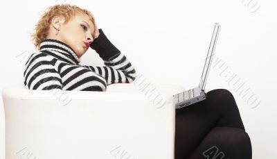 Nice blondgirl sitting on the chair with laptop