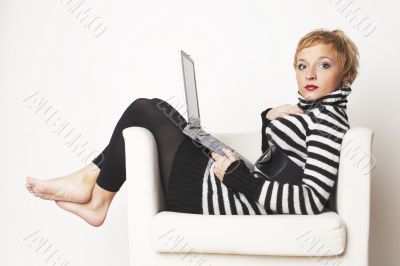 Nice blondgirl sitting on the chair with laptop
