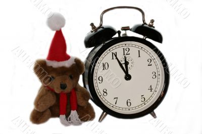 teddy bear in christmas red cap and old alarm clock