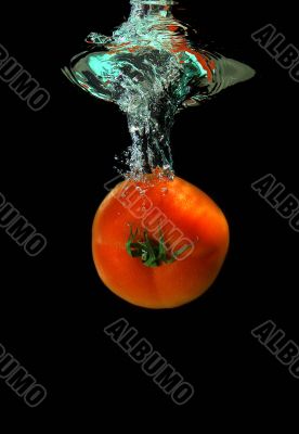 Tomato is falling into water