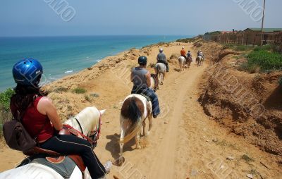riders walking along the sea