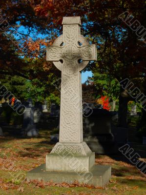 celtic cross at cemetery in autumn