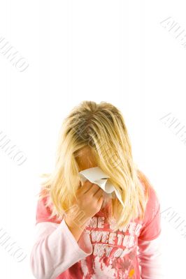 Young blond girl sneezing in the handkerchief