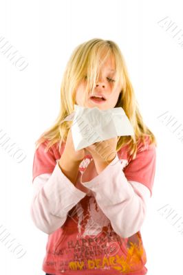 Young blond girl sneezing in the handkerchief