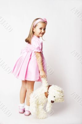 Nice young girl in pink on light background with teddy bear