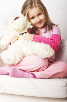 Nice young girl in pink on light background with teddy bear