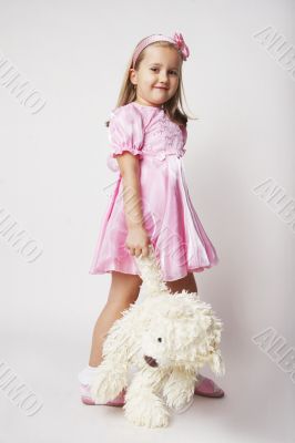 Nice young girl in pink on light background with teddy bear