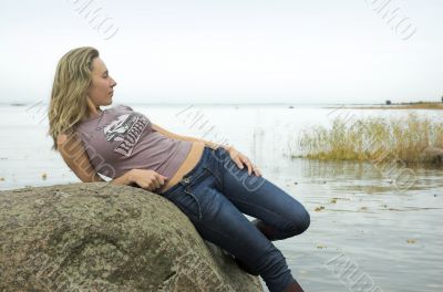 The beautiful girl has a rest on coast