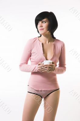 The girl in pink linen with a cup in hands