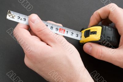 Hand with a measuring tape