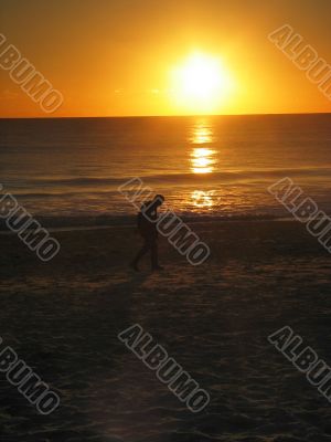 Man walking on Beach during Sunset
