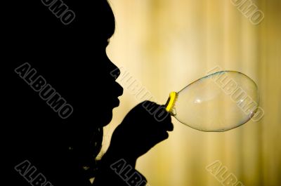 Little girl making bubble silhuette closeup
