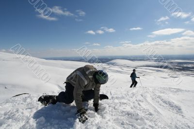 Snowboarder and skier in winter time