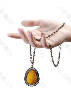 A hand with an amber pendant  isolated