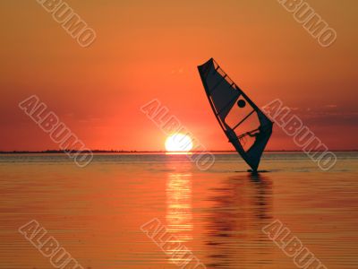 Silhouette of a windsurfer on waves of a gulf