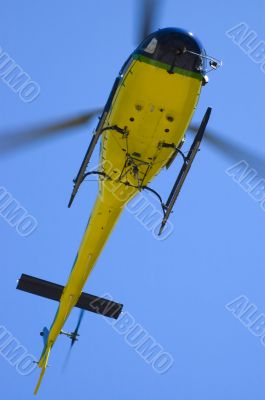 Yellow helicopter in blue sky