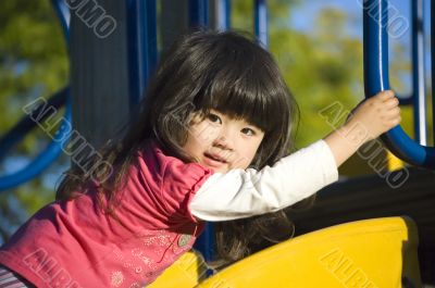 Cute little girl on the slide at playground