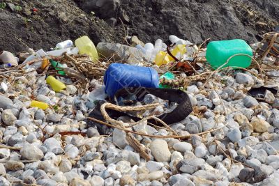 Plastic and rubber garbage on a stony beach