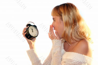 Young blond woman show time on alarm clock.