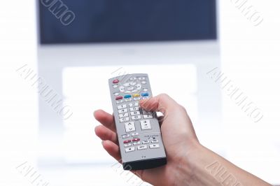 Hand with remote control and tv set