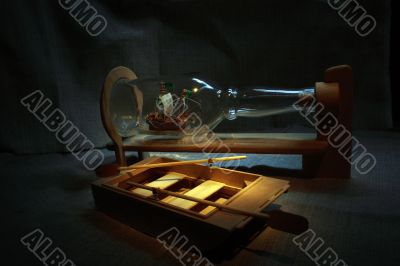 Naturmorte with hand-made ship in bottle and boat