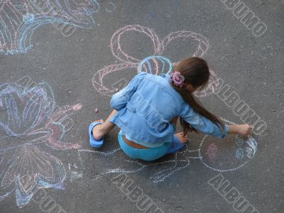 female child drawing picture with chalk