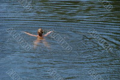 single figure swimming in wide water surface