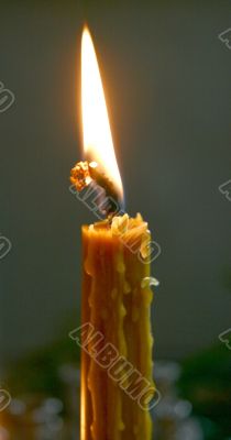 Alone candle flame upon black background