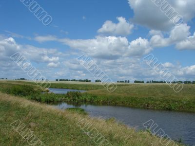 summer field with river uder cloudy deep sky