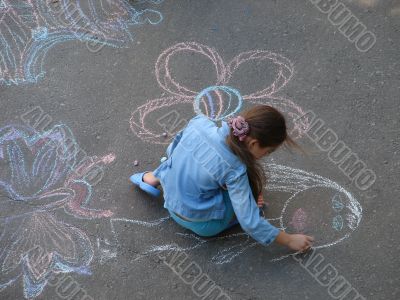 female child drawing picture with chalk