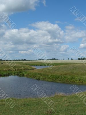 summer field with river uder cloudy deep sky