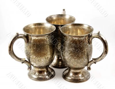 Three silver tankards isolated on white