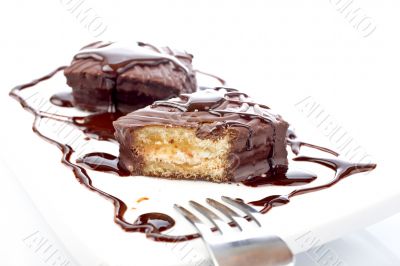 Two chocolate cupcakes with syrup and the fork