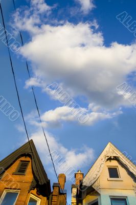 Cloud flying between roofs at sunset