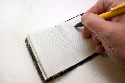 pen in hand on a notebook